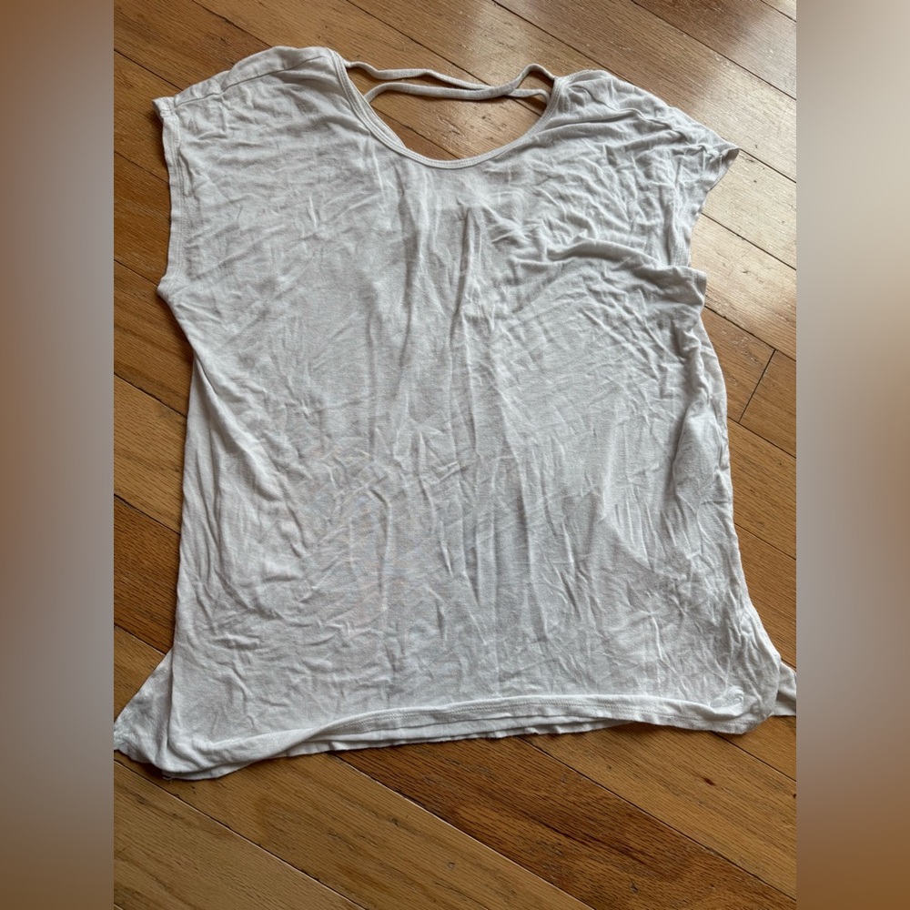 White shirt with criss cross detailing on the back.